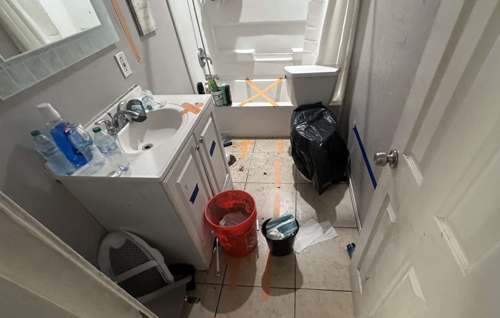 Bathroom in Phoenix with toilet removed and X tape marks for restoration after sewer line replacement or leak repair insurance claim