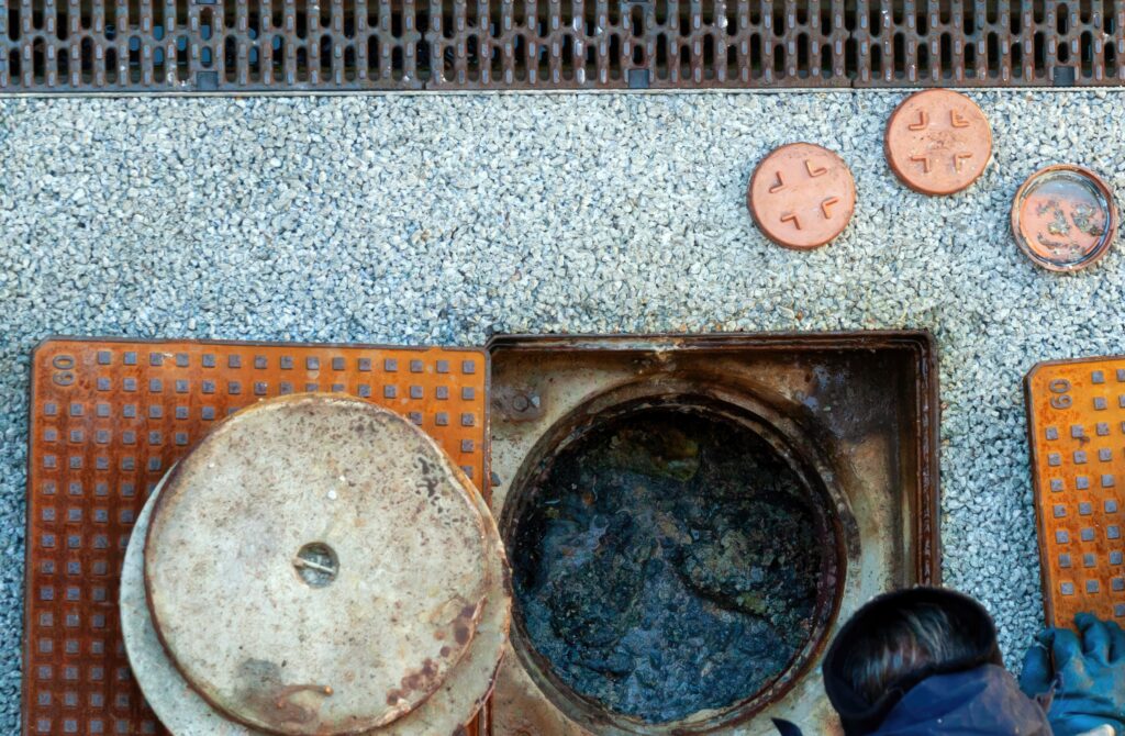 worker performing drain cleaning is essential before monsoon season to prevent blockage