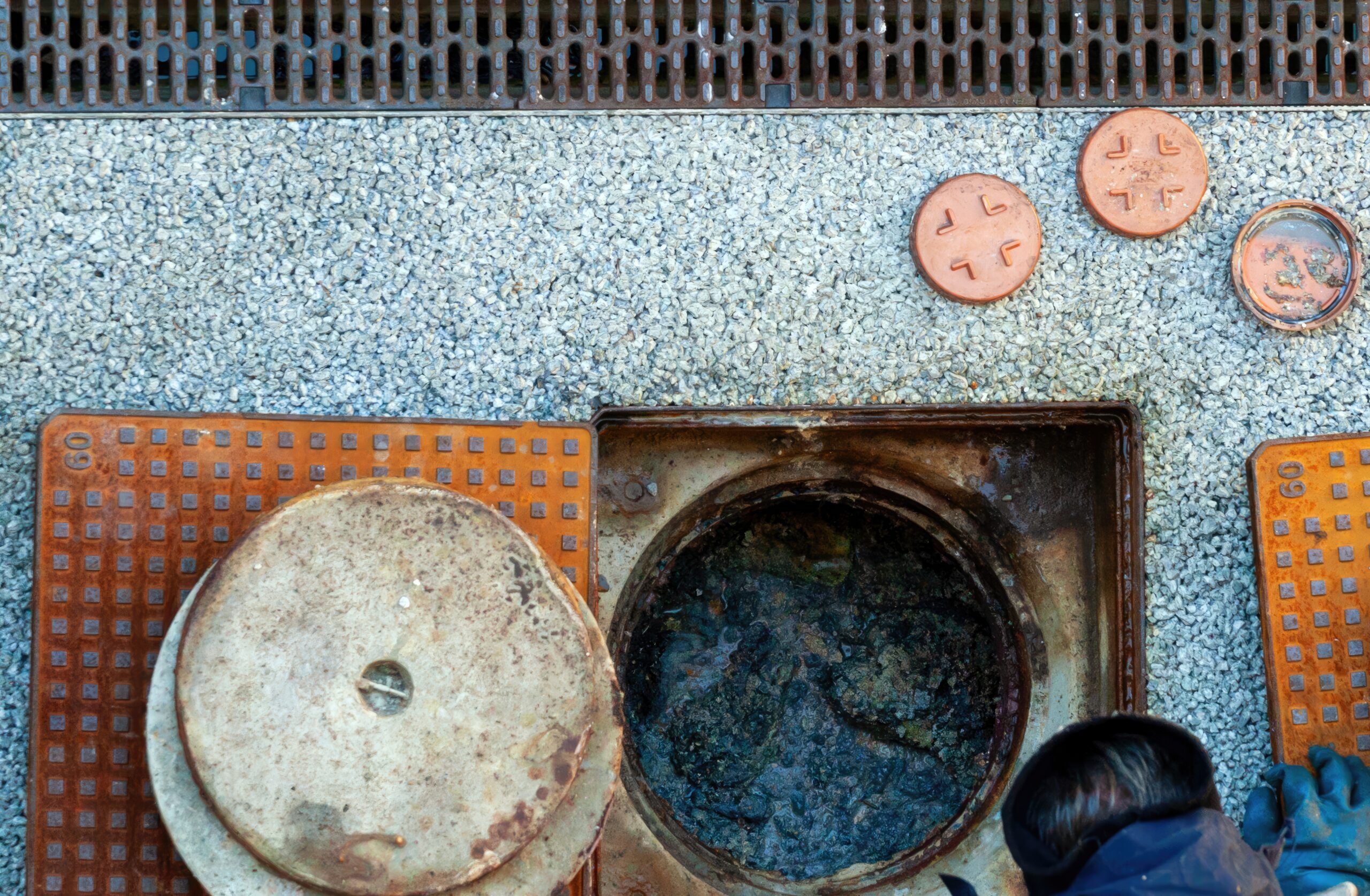 worker performing drain cleaning is essential before monsoon season to prevent blockage