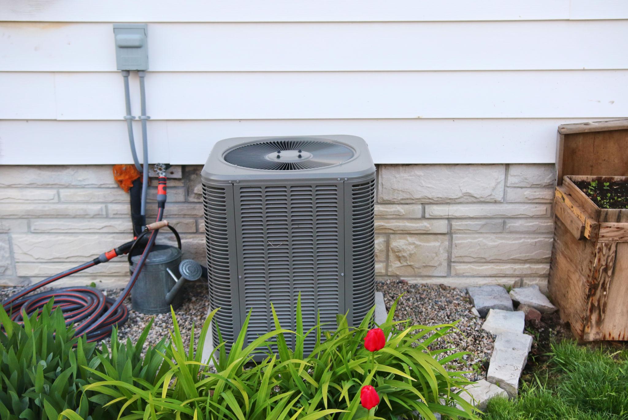 HVAC technician testing an air conditioner capacitor and checking for signs my AC capacitor is about to fail during a residential AC maintenance inspection.