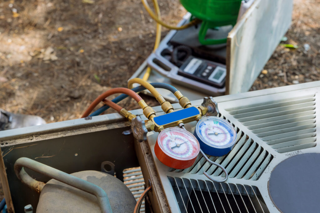 HVAC technician testing an air conditioner capacitor and checking for signs my AC capacitor is about to fail during a residential AC maintenance inspection.